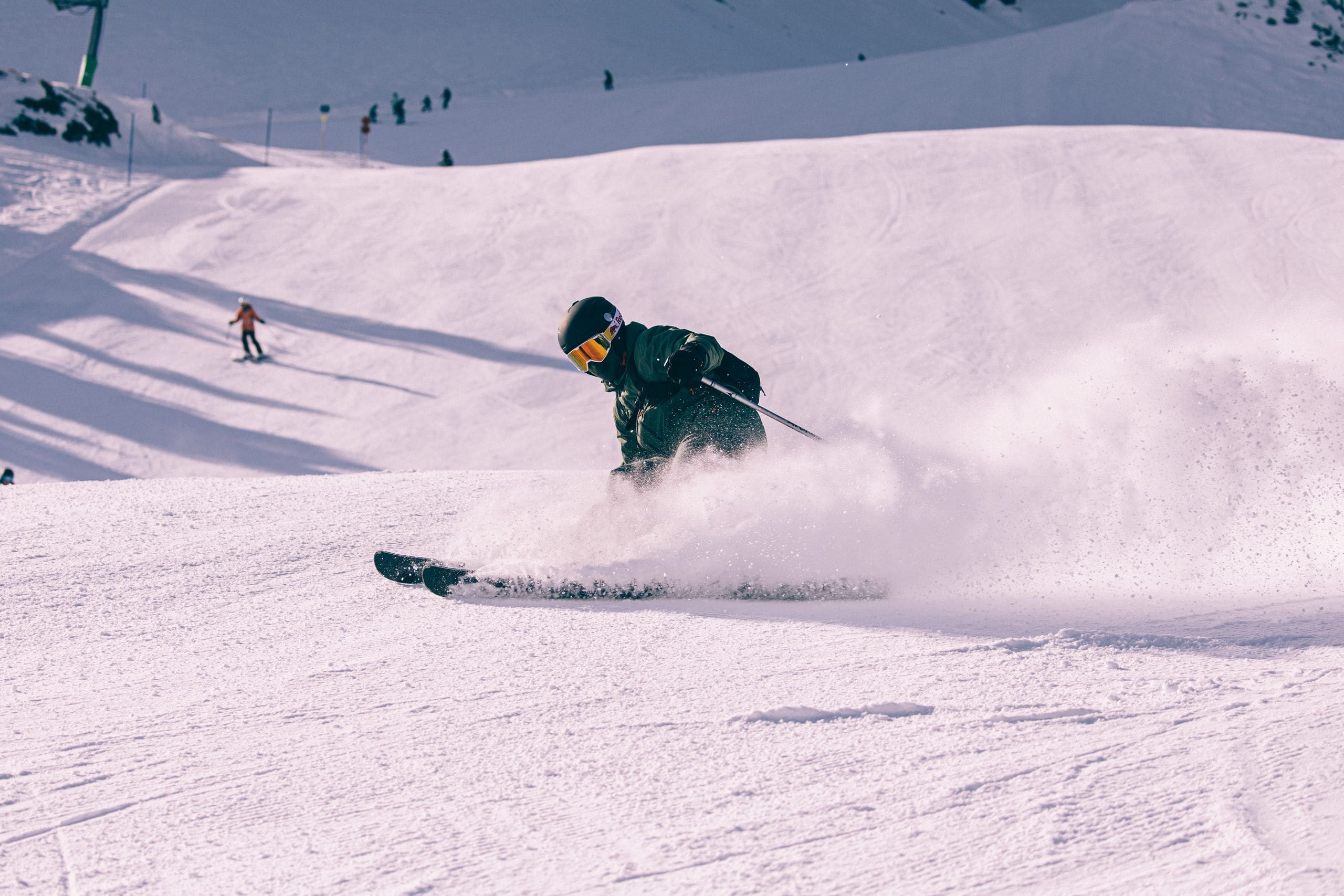 Skifahrer im Pulverschnee, ein zweiter Fahrer im Hintergrund